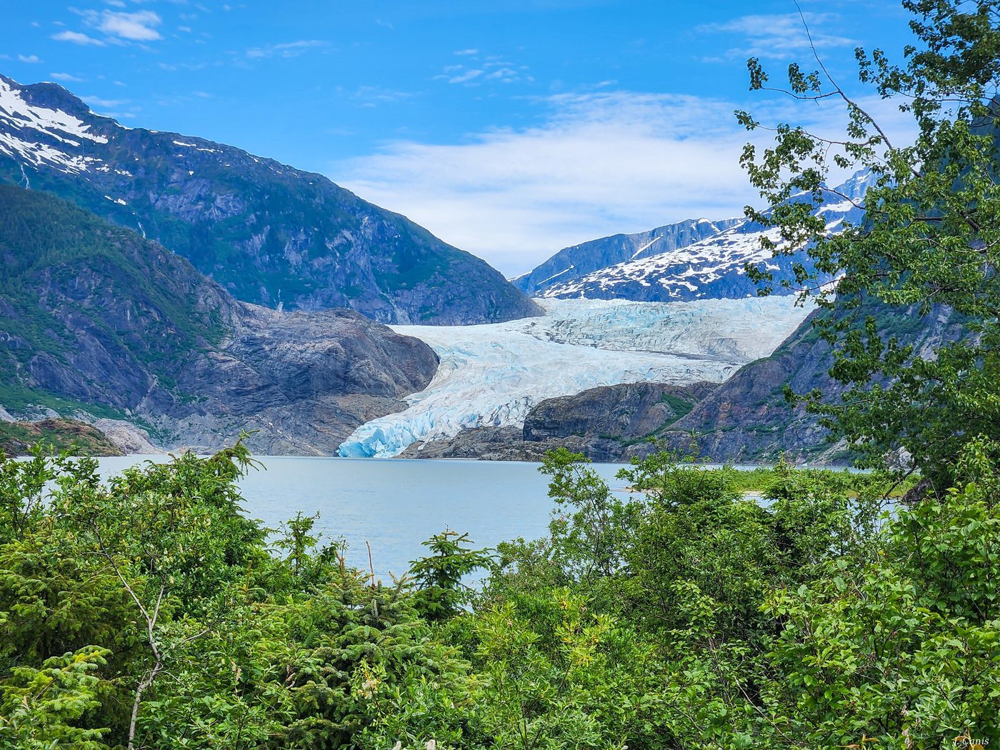Mendenhall Glacier — blue ice glacier flowing through Juneau Alaska forest, color photography by Jon Canis