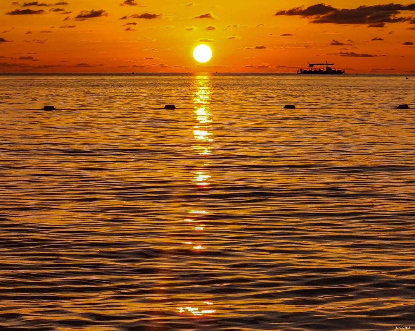 Cayman Low Sun — sun setting low over calm Caribbean waters, Cayman Islands photography by Jon Canis