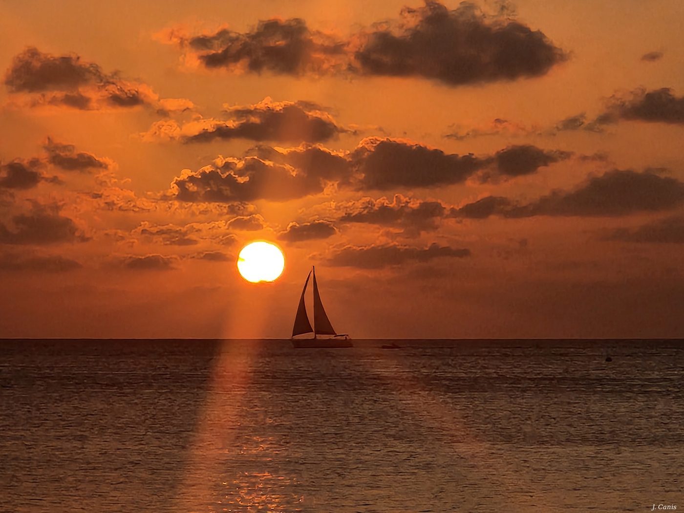 Cayman Sailboat — sailboat silhouetted against Caribbean sunset, Cayman Islands photography by Jon Canis